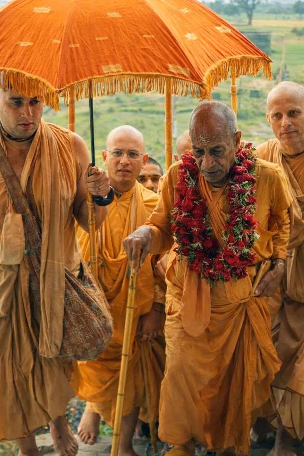 Srila Prabhupada walking with his disciples in saffron robes